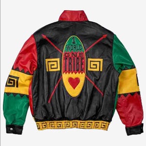 May include: Black leather jacket with red, yellow, and green detailing. The back displays the words "1 World One Tribe" and a heart-shaped emblem. The sleeves have geometric patterns and the jacket has a ribbed hem.