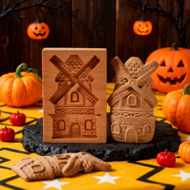 May include: Wooden windmill cookie mold and a baked cookie, with a carved windmill design. The cookie mold is rectangular, and the cookie is a 3D windmill shape. Pumpkins and Halloween decorations are in the background.