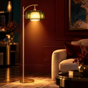 May include: A floor lamp with a slender gold-toned metal stand and a circular base. The lamp features a horizontal, translucent olive green glass shade that surrounds a smaller, white, vertically ribbed inner light diffuser.