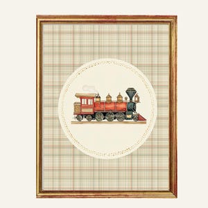 May include: Framed artwork featuring a watercolor illustration of a vintage red and gold train. The train is set against a cream-colored circle with a dotted border, placed over a plaid background. The frame is gold. The text "BUDS & BLOOMS Art that feels like home" is at the bottom.