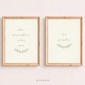 May include: Two vertical wall art prints in light wood frames. The left print features the text "where flowers bloom, so does peace" with a green leaf sprig. The right print features the text "love grows here" with a green leaf sprig.