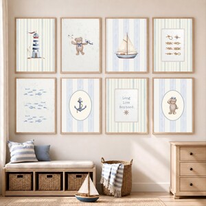 May include: A set of framed nautical-themed art prints. The prints depict a lighthouse, sailboat, teddy bear, anchor, and fish, set against a blue and white striped backdrop. The artwork is displayed above a bench with storage baskets.