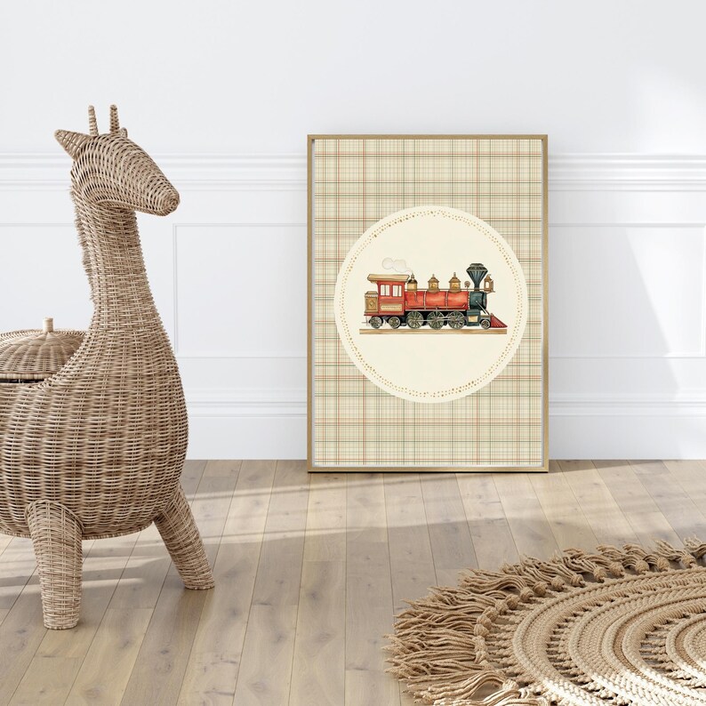 May include: A framed print featuring a watercolor illustration of a vintage red and gold train. The train is set against a cream-colored circle with a lace-like border, on a plaid background. The frame is a light brown color.