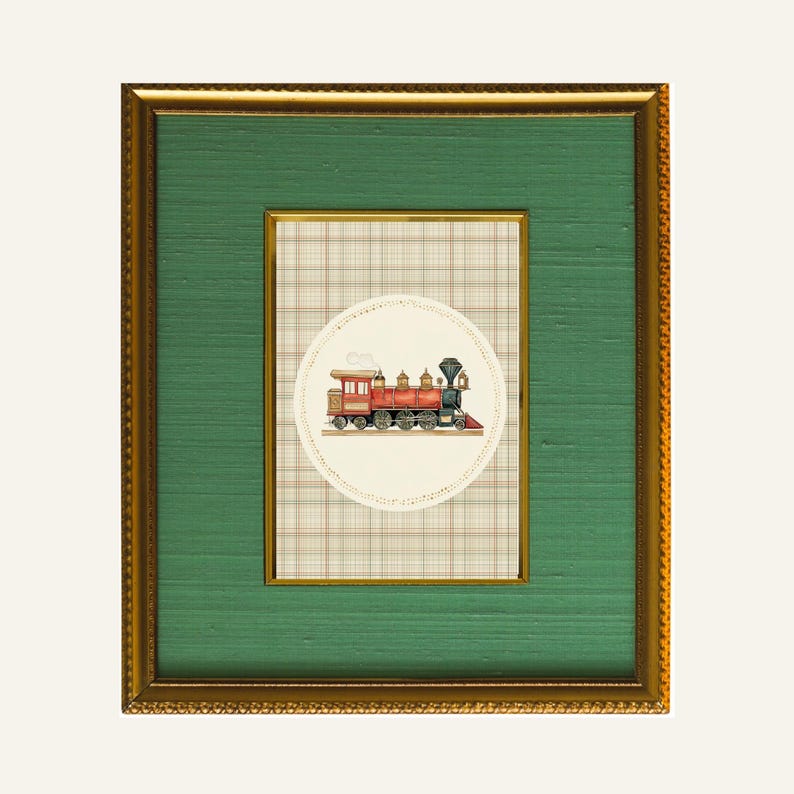 May include: A framed artwork featuring a vintage train illustration. The train is red and black, set against a cream-colored circle with a plaid background. The frame is gold with a green mat.