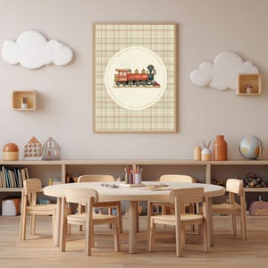 May include: A framed print featuring a vintage train illustration in red, gold, and black, set against a beige plaid background. The artwork is displayed in a child's playroom with a wooden table and chairs.