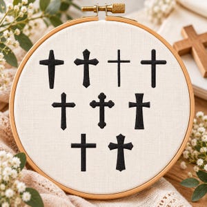 May include: An embroidery hoop containing off-white fabric with eight distinct black embroidered cross designs arranged in three rows. The wooden hoop features a metal tightening screw at the top center, securing the fabric in place.