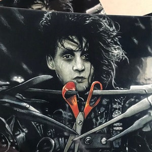 May include: A black and white illustration of a man with long black hair, wearing a black leather jacket with a red pair of scissors in his mouth. The background is dark and there are several other scissors in the image.