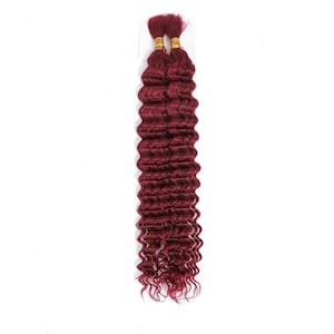 May include: Two bundles of deep wave burgundy hair extensions. The hair is a rich, dark red color with a wavy texture. The top of the bundles are secured with gold-colored bands. The background is plain white.