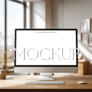 May include: A silver computer monitor with a white screen displaying the word "MOCKUP" in a serif font. A white keyboard and mouse are in front of the monitor on a wooden desk. The text "16:9 INNER FRAME RATIO" is at the top of the screen.