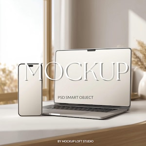 May include: A laptop and smartphone mockup on a white surface. The laptop screen displays the word "MOCKUP" and "PSD SMART OBJECT". The smartphone is positioned to the left of the laptop. The background is blurred, with a window and decorative elements.