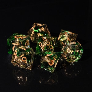 May include: A set of seven polyhedral dice with a green and gold color scheme. The dice are transparent with gold-colored numbers and internal accents. The dice are designed for tabletop role-playing games.