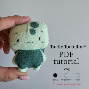 May include: A handmade felt turtle toy in shades of green, with the text "Turtle Tortellini PDF tutorial". The turtle has a square head with embroidered eyes and a smiling mouth. The tutorial difficulty is marked as "Easy".