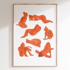 May include: Orange watercolor print featuring seven figures in various poses. The figures are depicted in a minimalist style, with simple lines and shapes. The artwork is framed in a light-colored wooden frame, suitable for wall decor.