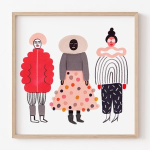 May include: A framed art print featuring three stylized figures in colorful outfits. The figures are depicted in a whimsical style, with bold colors and patterns. The artwork is set against a white background, and framed in a light wood frame.