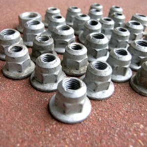 May include: A white ceramic mug with a black handle and the text "But First, Coffee" in a bold, black font. The mug is set against a blurred background, suggesting a cozy setting.