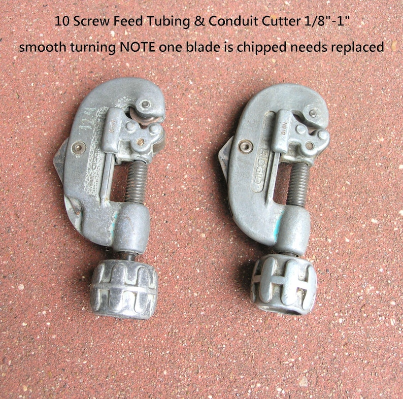 Puede incluir: Dos cortadores de tubos y conductos de alimentaci&oacute;n por tornillo de color plateado. El texto de la imagen dice: "10 Screw Feed Tubing & Conduit Cutter 1/8"-1" smooth turning NOTE one blade is chipped needs replaced."