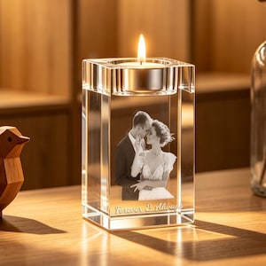 May include: A rectangular clear glass block candle holder featuring a laser-etched black and white photograph of a couple embracing. The text Forever & Always is engraved at the base. A lit tea light candle sits in the top circular cutout.