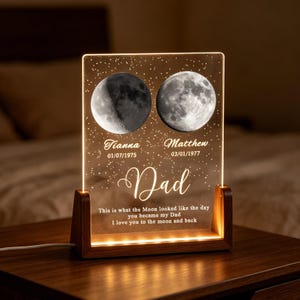 May include: A rectangular acrylic plaque with a warm light base, featuring two detailed moon illustrations, the names Tianna and Matthew with dates, the word Dad, and the text: This is what the Moon looked like the day you became my Dad.