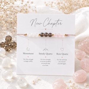 May include: A beaded bracelet on a white display card with the text New Chapter. The bracelet features white moonstone, dark brown smoky quartz, and light pink rose quartz beads separated by small gold-toned metal spacers on a thin brown cord.