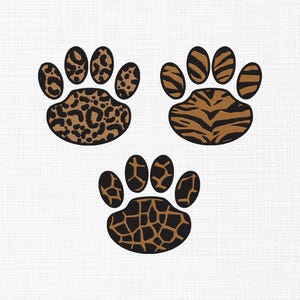 Op de afbeelding: Drie dierenpootafdrukken met verschillende patronen: luipaardprint, tijgerstrepen en giraffevlekken. Elke pootafdruk is zwart met bruine en bruingele markeringen, tegen een witte achtergrond.