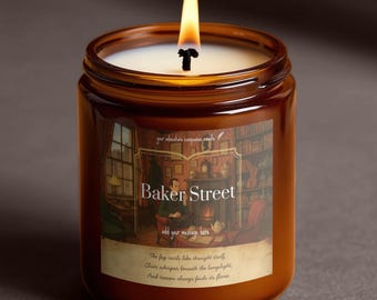 May include: A lit brown glass jar candle with a white wax interior. The label reads "Baker Street" with an illustration of a room. The candle's flame is yellow and orange. Text on the label includes "your adventure companion candle."