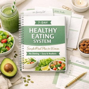 Può includere: Un quaderno a spirale intitolato "7-DAY HEALTHY EATING SYSTEM" con il sottotitolo "Simple Meal Plan for Women". L'immagine include un frullato, insalata, avocado, mandorle e fogli di pianificazione dei pasti.