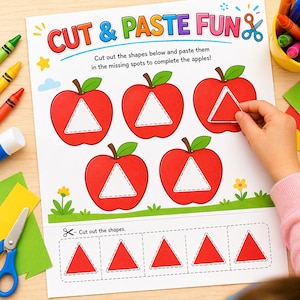 May include: A white activity sheet titled CUT & PASTE FUN featuring five red apple illustrations with empty triangular centers. Below, five red triangles are outlined for cutting. The sheet includes instructions to cut and paste shapes.