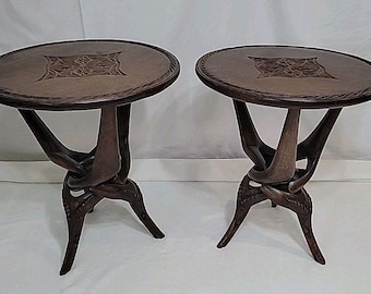 Par de mesas trípode plegables africanas de madera tallada entrelazadas, de estilo vintage, firmadas.