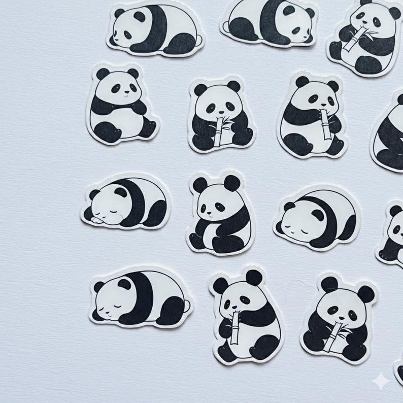 May include: A collection of individual die-cut stickers featuring black and white illustrations of giant pandas in various poses. Some pandas are depicted sitting upright while eating bamboo stalks, while others are shown lying down and sleeping.