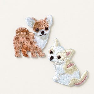 May include: Two embroidered Chihuahua dog patches. One patch is brown and white, standing with its tail up. The other patch is white and tan, sitting with its tail curled. Both patches have black eyes and noses.