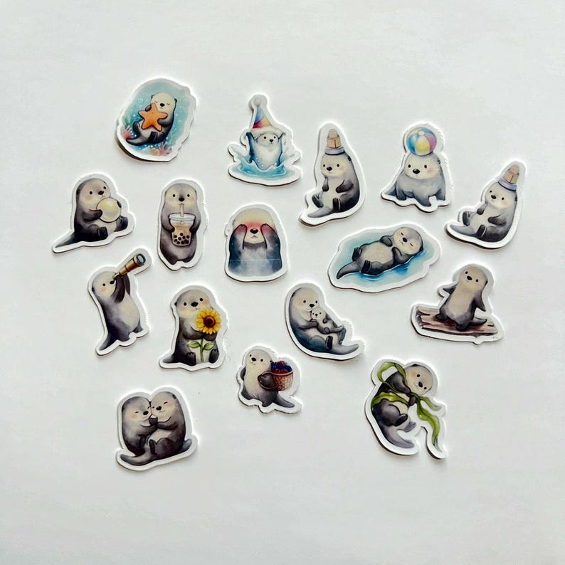 May include: A collection of sixteen individual die-cut stickers featuring illustrated sea otters in various poses. The otters are depicted holding items like a starfish, a sunflower, a boba tea, a telescope, and a basket, or wearing party hats.