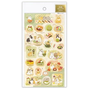 May include: A sheet of decorative stickers featuring illustrations of rabbits and Japanese sweets. The stickers are in various shapes and sizes, with a color palette of green, white, and brown. The text "NB CO., LTD. JAPAN" is printed on the top right.