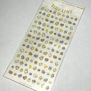 May include: A clear sticker sheet featuring multiple small chick illustrations in yellow, brown, and grey. The text "TINY TINY" is at the top, with "RELAXED AND COMFORTING" above it. The text "WE ARE HIYOKO" is at the bottom.