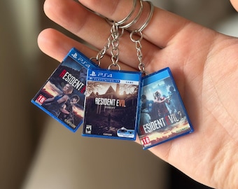 Resident Evil PS4 Game Case Sleutelhanger – RE7 Biohazard, RE2 Remake, RE3 Remake – Mini PlayStation-gamercadeau