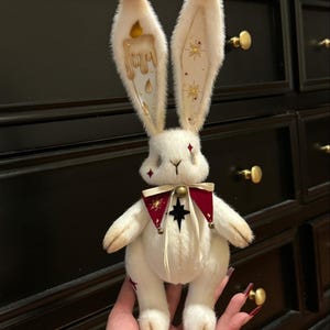 Puede incluir: Una taza de cer&aacute;mica blanca con un asa negra y el texto "But First, Coffee" en negrita negra. La taza est&aacute; sobre una superficie de madera. La taza mide aproximadamente 10 cm de alto.