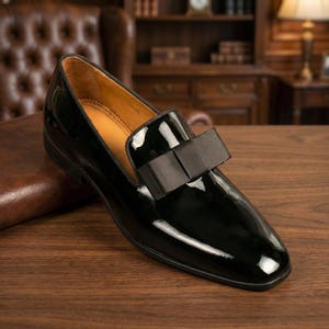Black patent leather men's formal loafers with elegant bow detail, handcrafted slip-on dress shoes ideal for tuxedo, weddings, and formal evening wear.