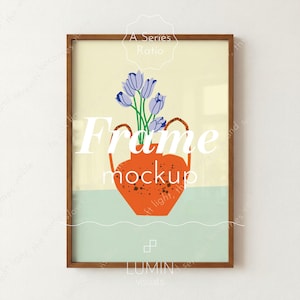 May include: A framed art print showing an orange vase with blue flowers. The vase has two handles and is set on a light green surface. The frame is brown, and the background is a soft yellow. The words "Frame mockup" are visible.