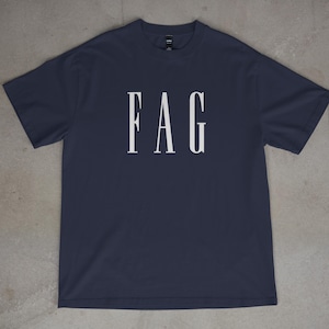 May include: Navy blue t-shirt with the white capital letters FAG printed across the chest. The shirt is made of a soft material and has a crew neck.