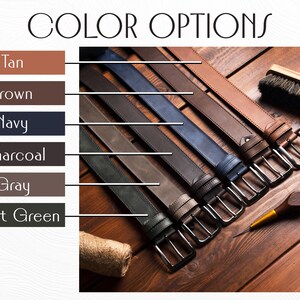 Puede incluir: Imagen que muestra una selecci&oacute;n de cinturones de cuero en varios colores: marr&oacute;n, azul marino, carb&oacute;n, gris y verde bosque. Cada cintur&oacute;n tiene una hebilla plateada. El texto "COLOR OPTIONS" est&aacute; en la parte superior.