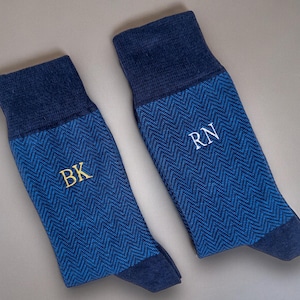 Pode incluir: Dois pares de meias azuis com um padr&atilde;o de espinha de peixe. Um par tem "BK" bordado em dourado, o outro "RN" bordado em branco. As meias t&ecirc;m punho, calcanhar e biqueira azul escuro.