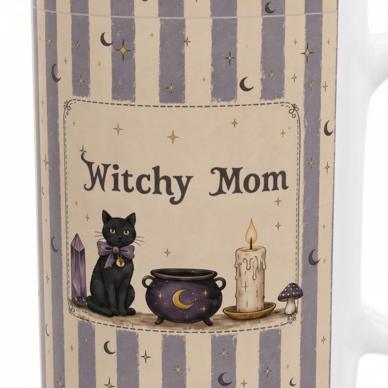 May include: A white ceramic mug featuring a vertical lavender and cream striped pattern with celestial motifs. The central graphic displays the text "Witchy Mom" above a black cat with a purple bow, a purple cauldron, a lit candle, and a mushroom.