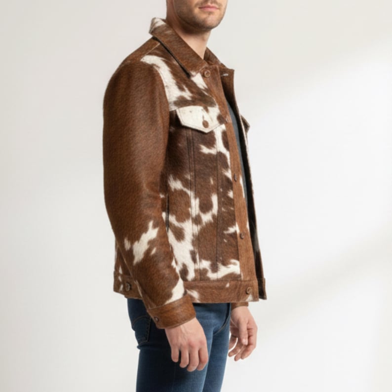 Puede incluir: Chaqueta de piel de vaca marr&oacute;n y blanca con cuello cl&aacute;sico, cierre de botones y dos bolsillos en el pecho. La chaqueta est&aacute; hecha de un material texturizado y tiene un dise&ntilde;o de inspiraci&oacute;n occidental. La chaqueta se combina con unos vaqueros azules.