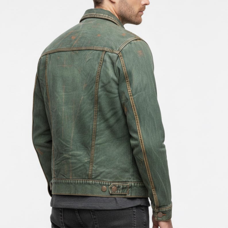 Pode incluir: Jaqueta jeans verde desgastada com gola cl&aacute;ssica e bot&otilde;es. A jaqueta apresenta costuras vis&iacute;veis em cor marrom contrastante e dois bolsos abotoados na cintura. Apar&ecirc;ncia desgastada.