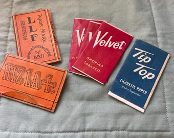 Collection of vintage Rizla+, Velvet, and Tip Top tobacco paper packets.