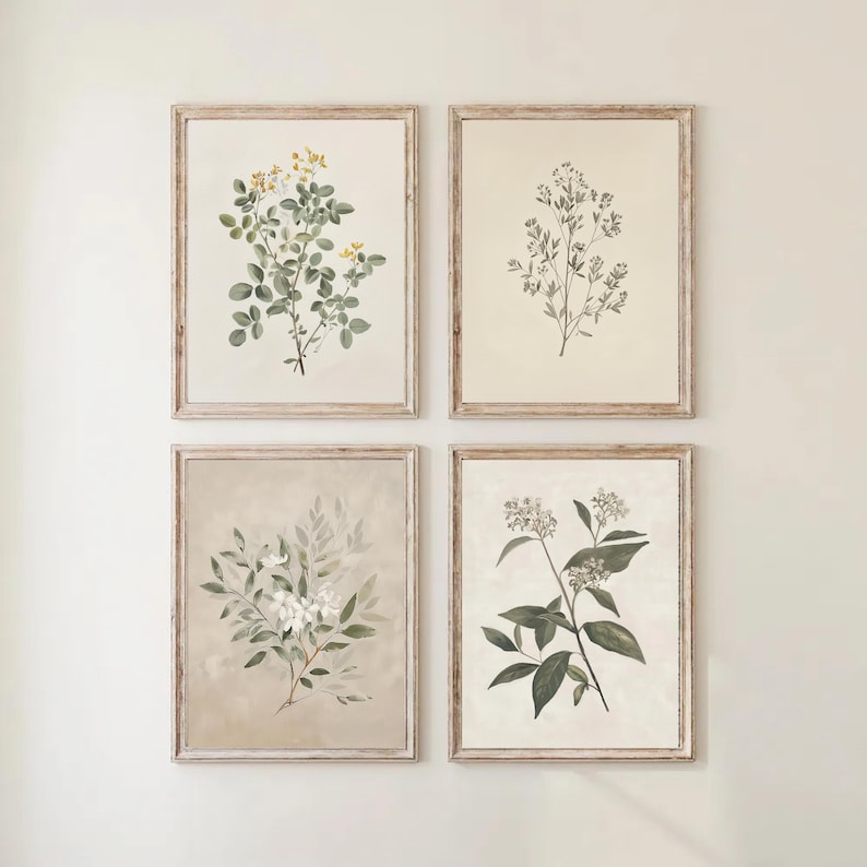 May include: Four framed botanical prints. Each print features a different illustration of plants and flowers in shades of green, white, and yellow. The frames are a light brown color, and the prints are displayed against a white wall.