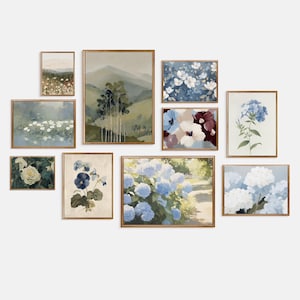 May include: A collection of framed floral and landscape art prints. The prints feature various flowers, including hydrangeas and white blooms, and scenic views of mountains and fields. The frames are a warm, natural wood tone.