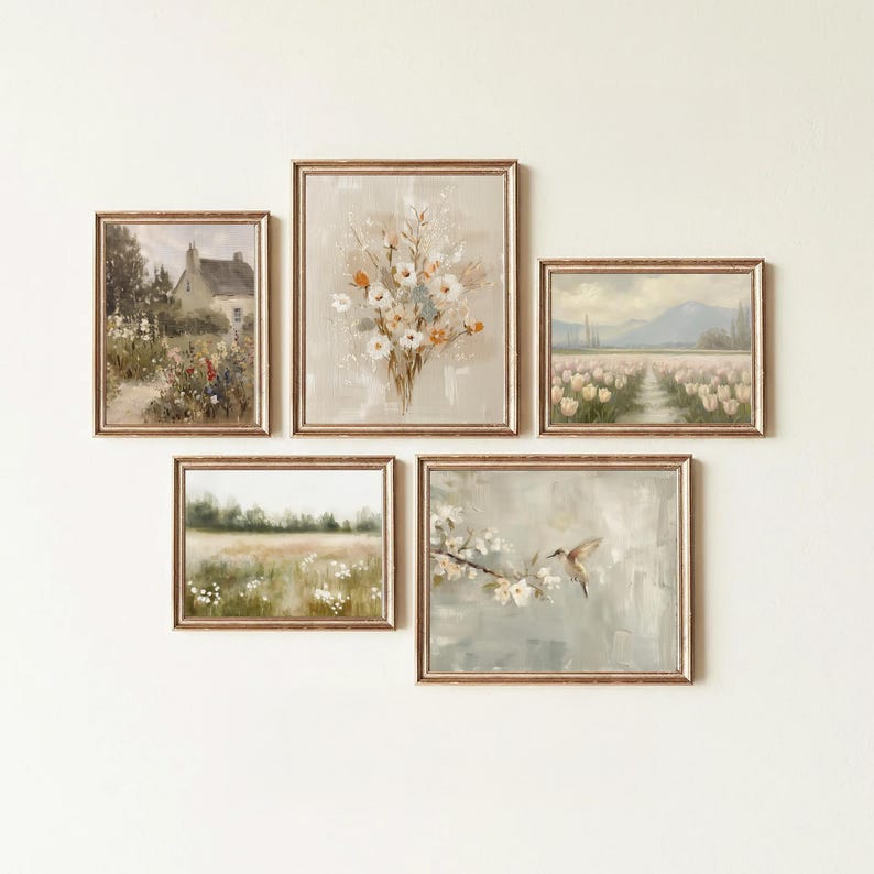 May include: Five framed landscape paintings with gold-colored frames are displayed on a white wall. The paintings depict scenes of a house, flowers, a field, a tulip field, and a hummingbird. The artwork has a vintage, rustic aesthetic.