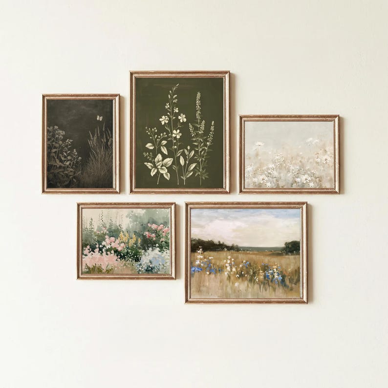 May include: A collection of five framed botanical art prints. The prints feature floral and landscape scenes in muted tones of green, beige, and pink. The frames have a gold finish, and the artwork is arranged on a white wall.