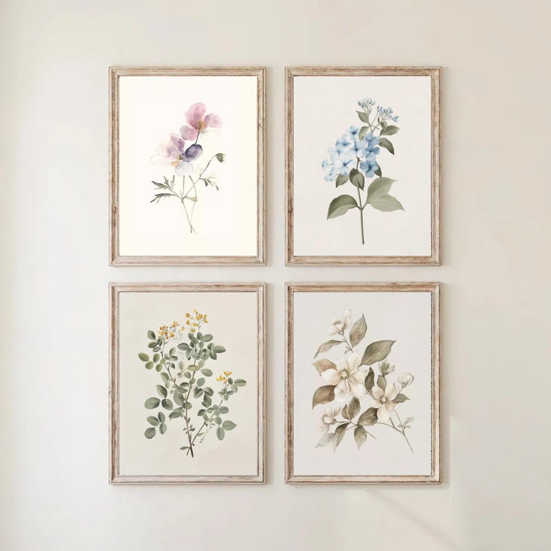 May include: Four framed botanical prints. Each print features a watercolor illustration of different flowers in shades of pink, blue, yellow, and white. The frames are made of light-colored wood, adding a rustic touch to the artwork.