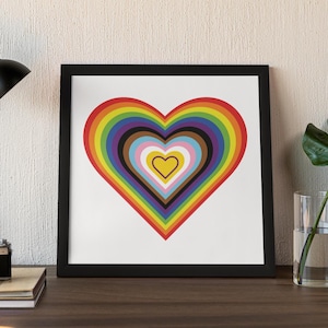 Puede incluir: Una pieza de arte mural enmarcada de forma cuadrada que presenta un gráfico centrado de corazones concéntricos en un espectro de arcoíris. El diseño incluye bandas de colores rojo, naranja, amarillo, verde, azul, violeta, marrón, negro, azul claro, rosa y blanco.
